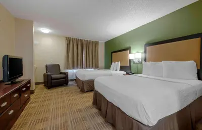 a hotel room with two beds and a television at Extended Stay America Select Suites - Orlando - Conven Ctr - Sports Complex in Orlando