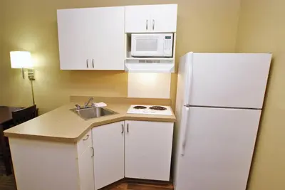 a kitchen with a white refrigerator and a sink at Extended Stay America Select Suites - Orlando - Conven Ctr - Sports Complex in Orlando
