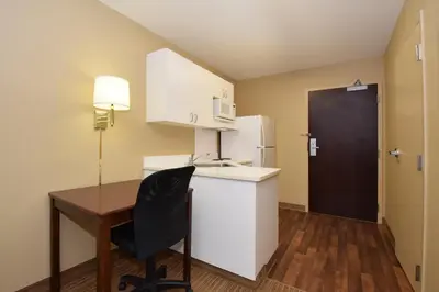 a small kitchen with a desk and a refrigerator at Extended Stay America Select Suites - Orlando - Conven Ctr - Sports Complex in Orlando