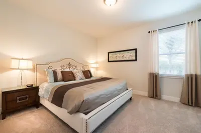 a bedroom with a large bed and a window at Groovy Mouse House with private pool in Orlando