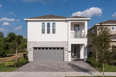 a white house with a garage at Groovy Mouse House with private pool in Orlando