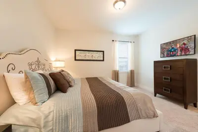 a bedroom with a bed and a dresser in it at Groovy Mouse House with private pool in Orlando