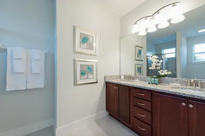 a bathroom with two sinks and a large mirror at Groovy Mouse House with private pool in Orlando