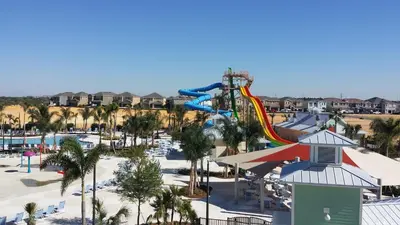 an aerial view of a water park with a roller coaster at Groovy Mouse House with private pool in Orlando