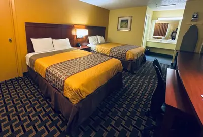 a hotel room with two beds and a desk at Budget Inn Of Orlando in Orlando