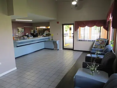 a living room with couches and a kitchen and a counter at Budget Inn Of Orlando in Orlando