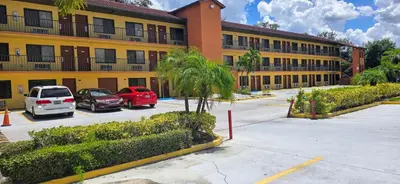 a large building with cars parked in a parking lot at Budget Inn Of Orlando in Orlando