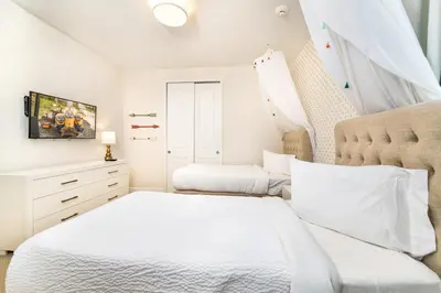 a white bedroom with two beds and a window at Exquisite Home With Media Room & Games With Waterpark & Resort Access Near Disney At Encore Resort- 7600Mc in Kissimmee