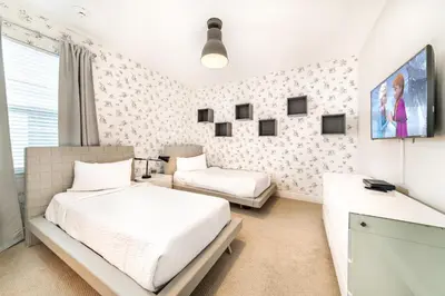 a bedroom with two beds and a tv at Exquisite Home With Media Room & Games With Waterpark & Resort Access Near Disney At Encore Resort- 7600Mc in Kissimmee