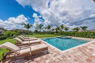 a pool with chaise lounge chairs and a swimming pool at Exquisite Home With Media Room & Games With Waterpark & Resort Access Near Disney At Encore Resort- 7600Mc in Kissimmee