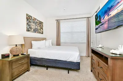 a bedroom with a bed and a flat screen tv at Luxury Home With Themed Rooms, Game Room And Waterpark & Resort Access Near Disney At Encore Resorts Reunion - 260Cl in Kissimmee