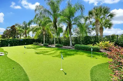 a yard with golf balls in the grass with palm trees at Luxury Home With Themed Rooms, Game Room And Waterpark & Resort Access Near Disney At Encore Resorts Reunion - 260Cl in Kissimmee