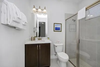 a bathroom with a toilet and a sink and a shower at Vibrant Elite Home With Private Pool, Theater Room And Waterpark & Resort Access Near Disney At Encore Resort - 7605Mc in Kissimmee