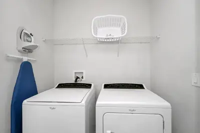 a laundry room with two machines and a light at Vibrant Elite Home With Private Pool, Theater Room And Waterpark & Resort Access Near Disney At Encore Resort - 7605Mc in Kissimmee