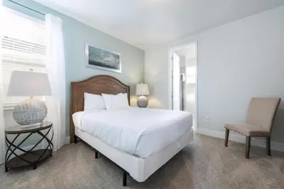 a bedroom with a white bed and a chair at Modern Home Near Disney With Private Pool, Media Room And Waterpark & Resort Access At Encore Resorts Reunion - 7576Mr in Kissimmee