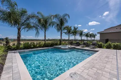a swimming pool with palm trees in a yard at Modern Home Near Disney With Private Pool, Media Room And Waterpark & Resort Access At Encore Resorts Reunion - 7576Mr in Kissimmee