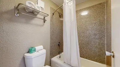 a bathroom with a white toilet and a shower at Days Inn by Wyndham Orlando Downtown in Orlando