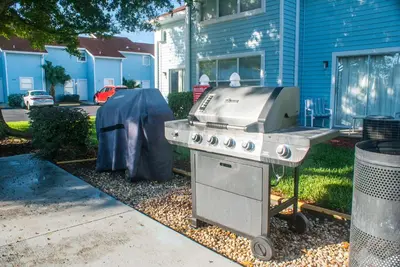 a grill in a yard in front of a house at Villas at Fortune Place in Kissimmee