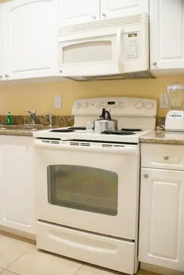 a kitchen with a white stove and a microwave at Villas at Fortune Place in Kissimmee