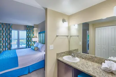 a bathroom with a bed and a sink in a room at Vacation Village Orlando, Celebration in Orlando