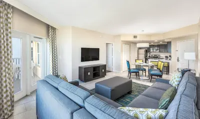 a living room with a blue couch and a tv at Vacation Village Orlando, Celebration in Orlando