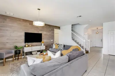 a living room with a gray couch and a tv at Veranda Palms 8 Bedroom Home with Pool 1722 in Kissimmee