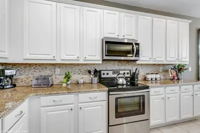 a white kitchen with white cabinets and appliances at Veranda Palms 8 Bedroom Home with Pool 1722 in Kissimmee