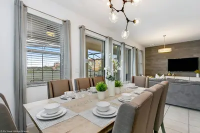 a dining room with a long table and chairs at Veranda Palms 8 Bedroom Home with Pool 1722 in Kissimmee