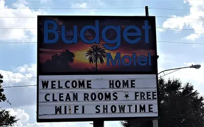 a sign for a buggie motel with a welcome sign at Budget Motel in Orlando