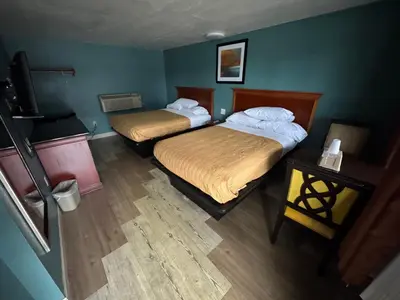 two beds in a small room with green walls at Budget Motel in Orlando
