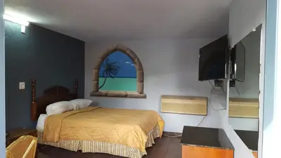 a bedroom with a bed and a window and a tv at Budget Motel in Orlando