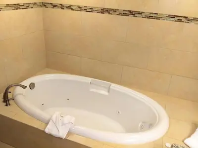 a white tub in a bathroom with a tile wall at Grand Lake & Lifetime of Vacations Resorts in Orlando