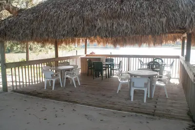 a deck with tables and chairs and a straw roof at Grand Lake & Lifetime of Vacations Resorts in Orlando