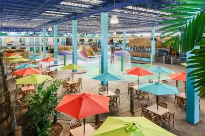 an outdoor patio with tables and umbrellas at Coco Key Hotel & Water Park Resort in Orlando