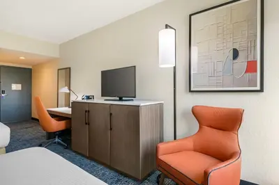a room with a bed and a desk and a tv at Best Western Plus Universal Inn - Free Shuttle to Universal Studios! in Orlando