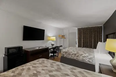 a hotel room with two beds and a desk at Americas Best Value Inn Orlando, FL in Orlando
