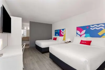 a hotel room with two beds and a flat screen tv at Baymont by Wyndham Orlando North Millenia in Orlando