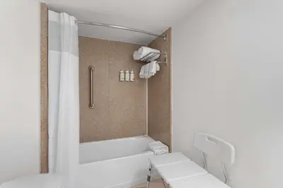 a bathroom with a bath tub and a toilet at Baymont by Wyndham Orlando North Millenia in Orlando