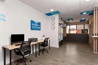 an office with a desk with a computer and chairs at Baymont by Wyndham Orlando North Millenia in Orlando