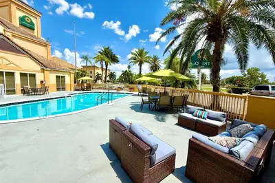 a patio with two couches and a swimming pool at La Quinta by Wyndham Orlando Universal area - Free Shuttle to Universal in Orlando