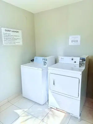 a laundry room with a washer and dryer in it at La Quinta by Wyndham Orlando Universal area - Free Shuttle to Universal in Orlando