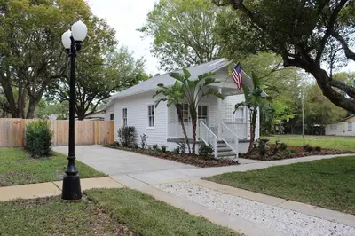 a white house with an american flag and a street light at The Shed in Sanford