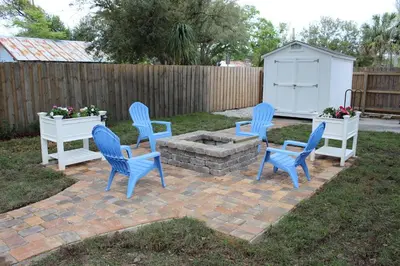 four blue chairs and a fire pit in a yard at The Shed in Sanford