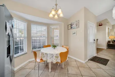 a dining room with a table and chairs and windows at Indian Creek 3.5 miles from Disney in Orlando
