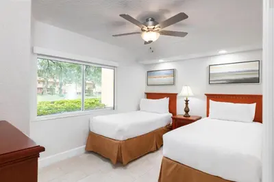 two beds in a room with a ceiling fan at Westgate Leisure Resort in Orlando