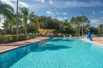 a large swimming pool with blue water at Orlando RV Resort in Orlando