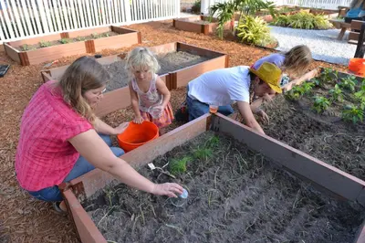 a group of people planting plants in a garden at Orlando RV Resort in Orlando