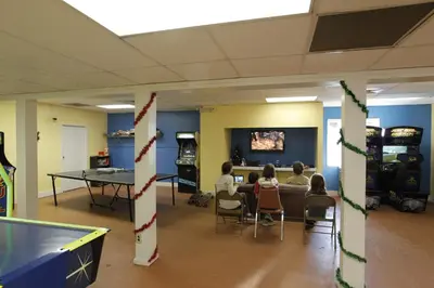 a group of people sitting in a room with ping pong tables at Orlando RV Resort in Orlando