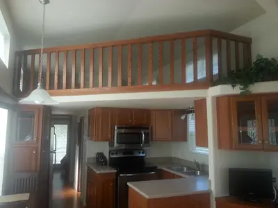 a kitchen with wooden cabinets and a wooden staircase at Orlando RV Resort in Orlando