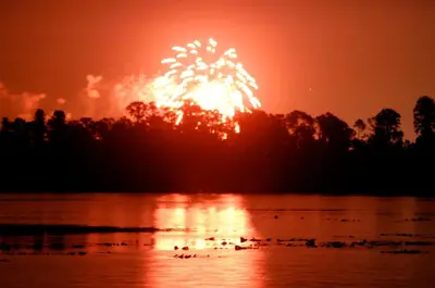 a firework display over a lake with ducks in the water at Orlando RV Resort in Orlando